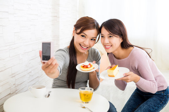 Two beautiful woman having dessert together in coffee shop