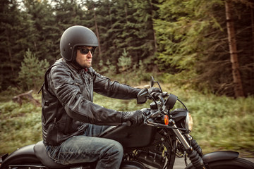 Fototapeta premium Man seat on the motorcycle on the forest road.