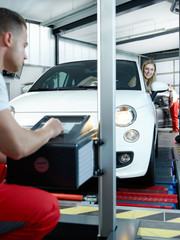 Car mechanic testing light of car in garage 