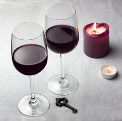 Two glasses of wine with old key, and two candles
