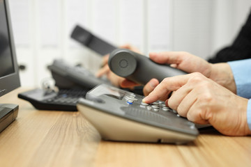 business people in office calling customers on land line telepho