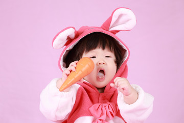 baby dressed in Easter bunny ears with carrot