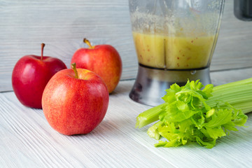 Apples and a bunch of celery, and a food processor with a smooth