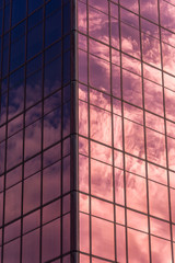 Sky and clouds reflected in windows of office building