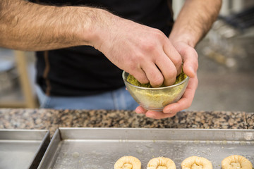 Hands baking dough with rolling pin on wooden table
