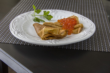 Pancakes with red caviar on a plate