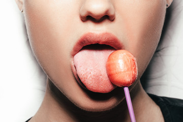 Woman licking  red shiny lollipop