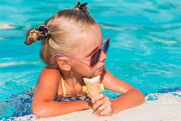 on a sunny day the girl in sunglasses with ice cream relaxing in the pool
