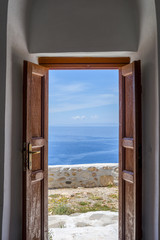 Open door to the sea. Wooden house entrance in Mykonos facing th