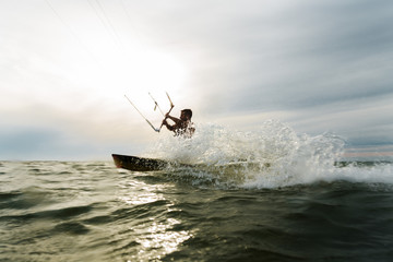 Fototapeta na wymiar Surfer splashing in front of the sun