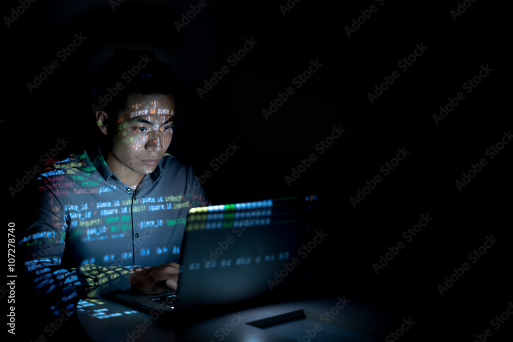 Wall mural Software developer coding on his laptop at night