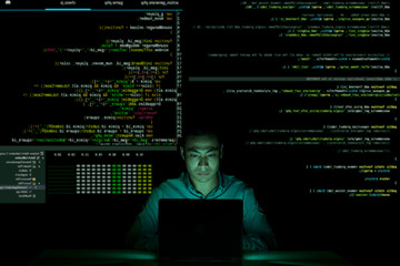 Portrait of Asian developer coding in dark office