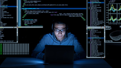 Young programmer in headphones working on new project