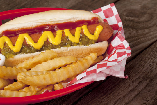 a plate with hotdog sandwich and potato fries