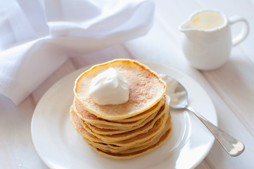 Light breakfast. Fresh pancakes on white plate  in morning light