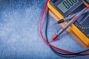 Digital electric tester on metallic background electricity conce