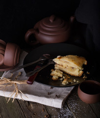 Piece of pie and pottery for tea on an old wooden table