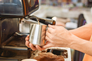 Fototapeta na wymiar Barista mixing milk on espresso machine for making coffee, Latte