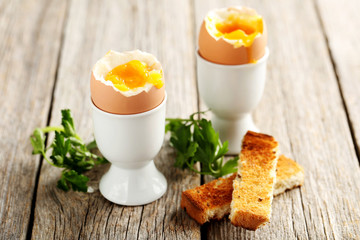 Boiled egg with toasts on a grey wooden table