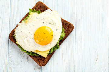 Fried eggs with toasts on blue wooden table
