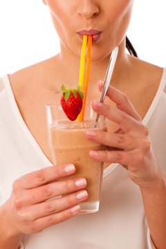 Woman drinking healthy fresh fruit smoothie decorated with red s