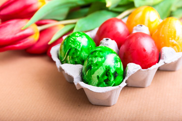 Sechs bunte Eierkerzen mit Tulpen
