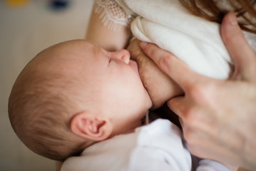 Obraz na płótnie Canvas Mother breastfeeding her newborn baby