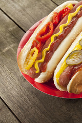 cropped image of hot dog sandwiches in red plate