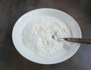 Dough for cheesecakes, spoon are in a white dish. Preparation for cooking. 