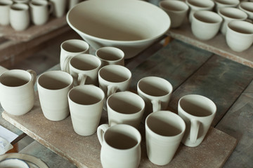 tabletop of unfinished ceramic or clay works in a pottery