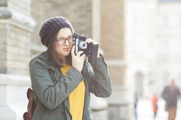 Young modern woman takeing pictures of architecture. She is on vecation.