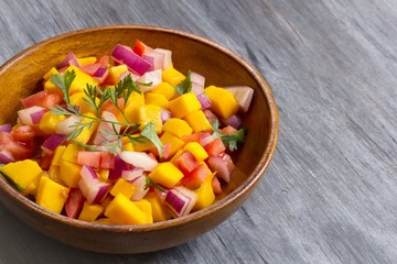 Homemade Mango salsa served in a wooden plate