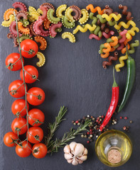 pasta of different colors, tomatoes, garlic, pepper, rosemary in