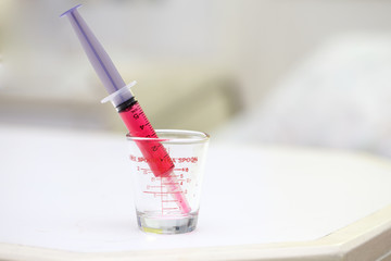 Red liquid drug in syringe