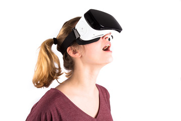 Une jeune fille avec des lunettes de réalité virtuelle sur fond blanc, la tête en l'air