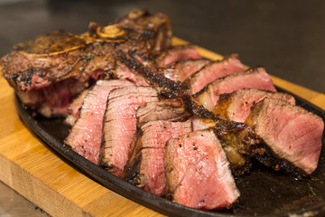 A selection of  grilledT Bone steak pieces off the bone on a metal plate