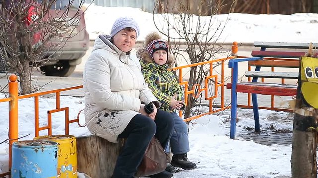 Grandmother and grandson playing in the park in winter