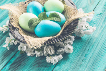 Naklejka premium colored eggs on a wooden background
