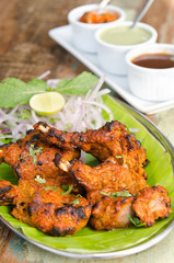 Delicious tandoori chicken starter, served with lime, onion, mint, yoghurt and sauces, on a banana leaf base.