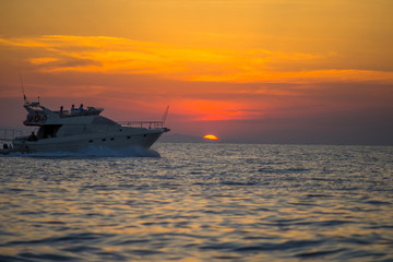 Luxurious boat sailing during sunset in Santorini, Greece.