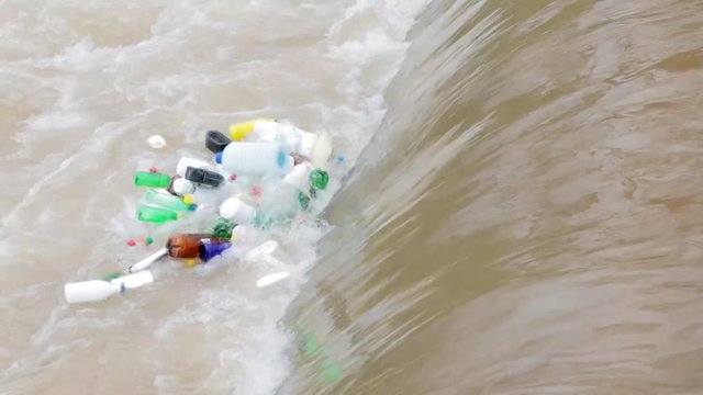 Plastic bottles float in a waterfall, environment pollution