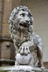 Fototapeta na wymiar Medici Lion holds the globe in Piazza della Signoria. Marble lion statue at the entrance (left side) of Loggia dei Lanzi in Florence, made by artist Flaminio Vacca in 1598