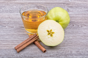 Apples, cinnamon and juice on a wooden background