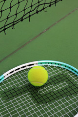 Tennis ball and racket on tennis court