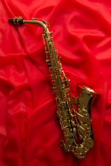 Naklejka premium beautiful golden saxophone on a red background