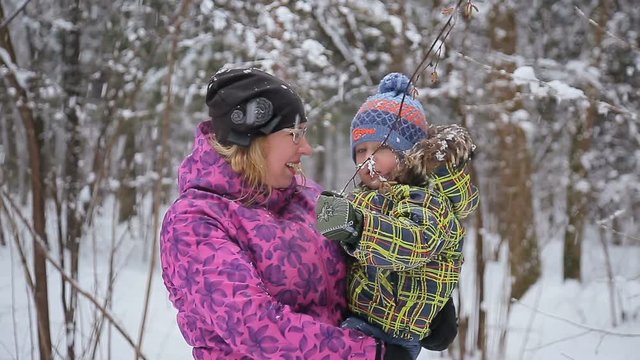 Happy mother and baby playing with snow. Winter fun, snow, happy children at winter time