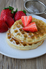 healthy breakfast waffle with strawberry  and maple syrup on top