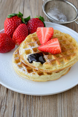 healthy breakfast waffle with strawberry  and maple syrup on top