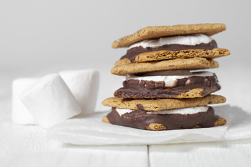 smores sandwich with white marshmallows on the side