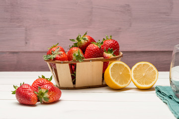 Strawberries in a small basket and lemon